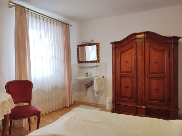Schrank, Waschbecken, Spiegel und Stuhl