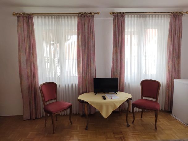 Tisch mit TV, 2 Stühle, 2 Fenster